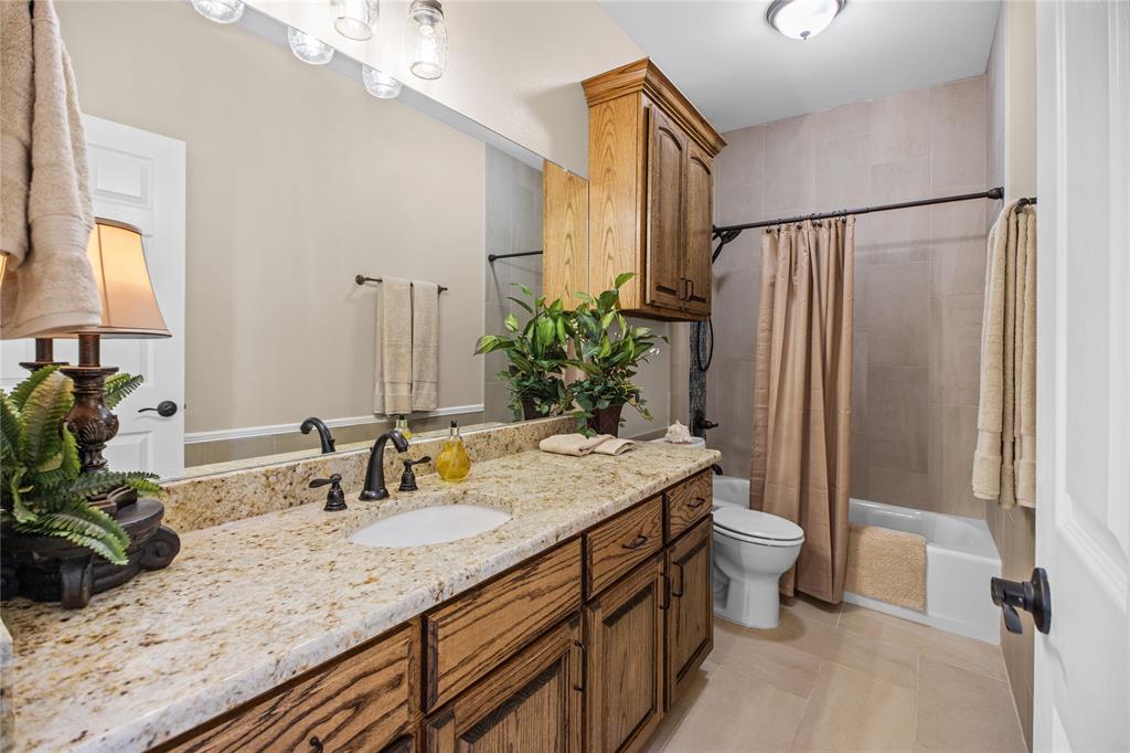 Hall bath with Granite counter, tile floors, & tub shower combo