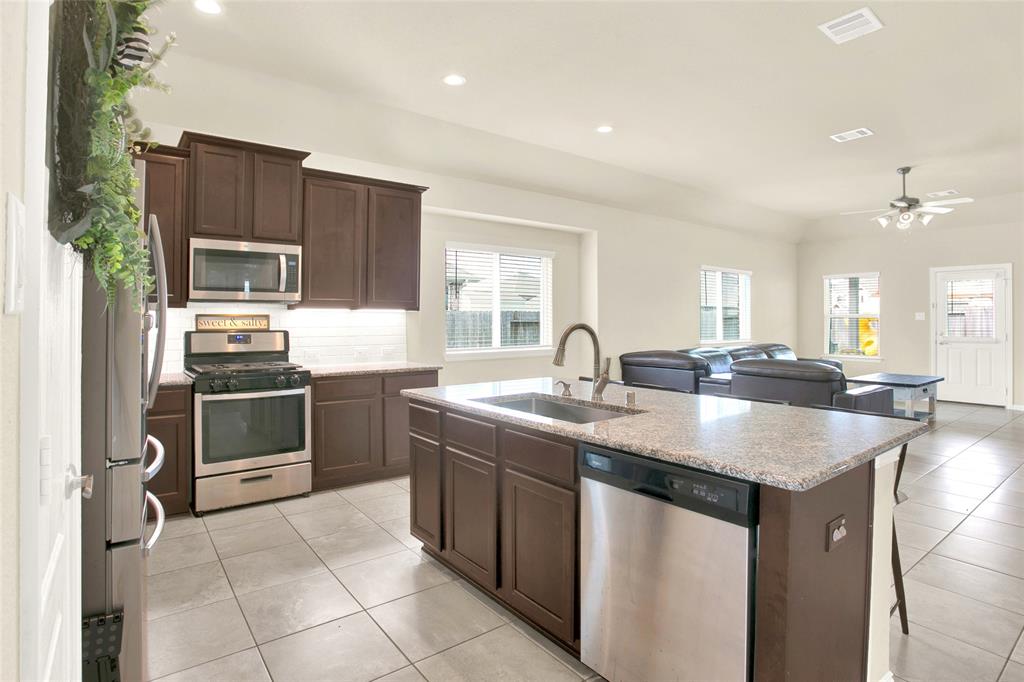 Very efficient kitchen with custom maple cabinets, stainless steel appliances, and a large island that includes a 8\