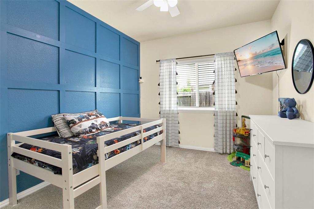 One of two secondary bedrooms with a beautiful painted wood accent wall.