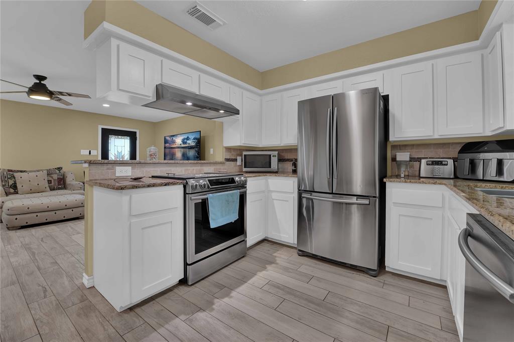 Stainless steel appliances. View to the family room. Refrigerator and microwave will stay with the property.