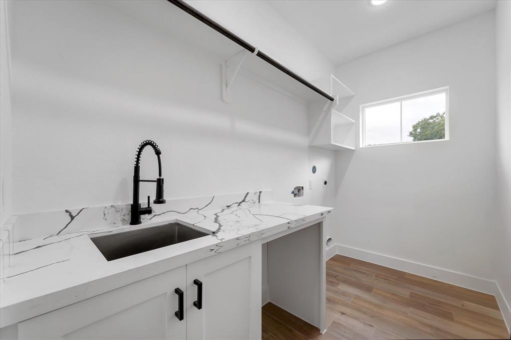 Laundry room with plenty of storage and a convenient sink!