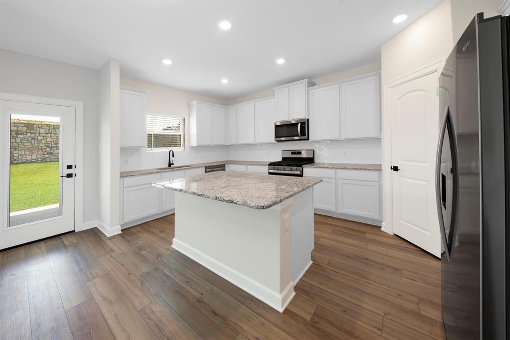 With an open layout, the kitchen island becomes the focal point, offering a spacious and inviting atmosphere that encourages family members to gather, chat, and enjoy each other\'s company while meals are prepared.