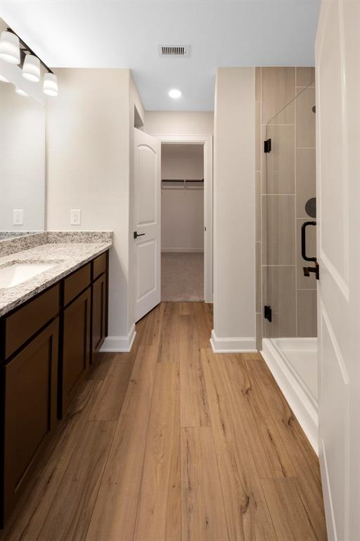 The large en-suite bathroom exudes luxury and relaxation, featuring a spacious walk-in shower that mimics the indulgent atmosphere of a high-end spa, offering a rejuvenating experience right at home.