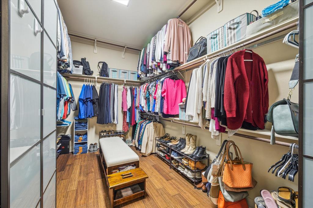 A well-organized walk-in closet with a variety of clothing, shoes, and accessories displayed on shelves and racks.