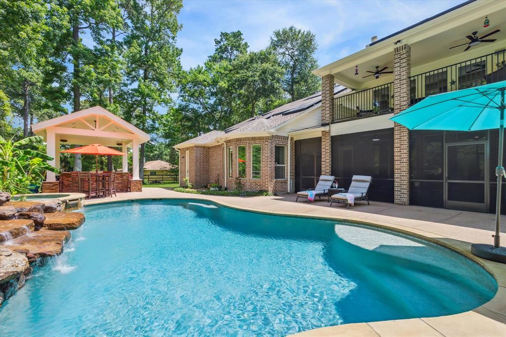 This outdoor paradise has a beautiful heated pool, waterfall, hot tub, covered balcony, screened in porch and an outdoor kitchen, as well as 1/2 bath!