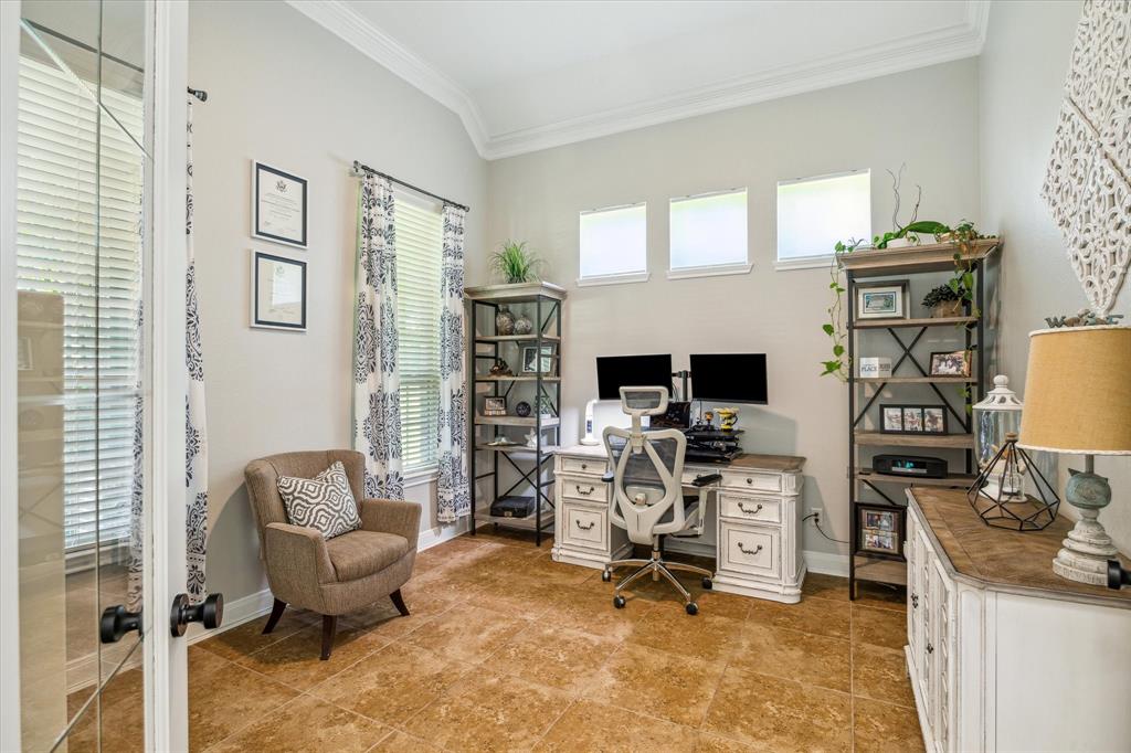 First floor home office with crown moldings. Bright and tidy with a neutral color scheme.