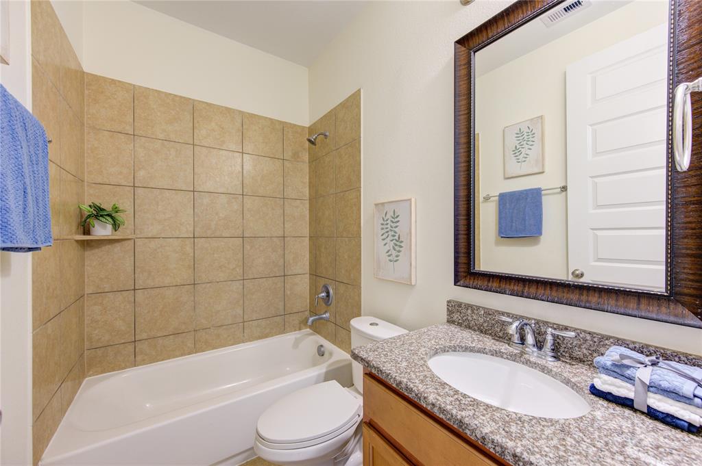 En suite bathroom for bedroom number 2 with granite counter tops, undermount sink, and shower/tumb combination.