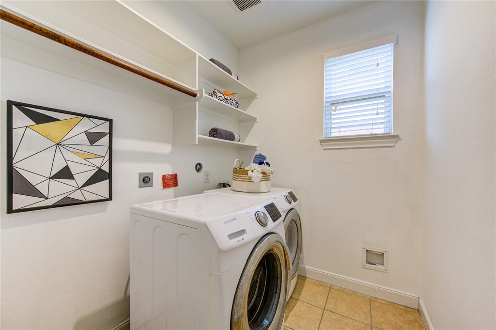 Extremely spacious Utility/Laundry room with built in shelving and hanging rod for convenience.  Even in the laundry room, there is excellent lighting!