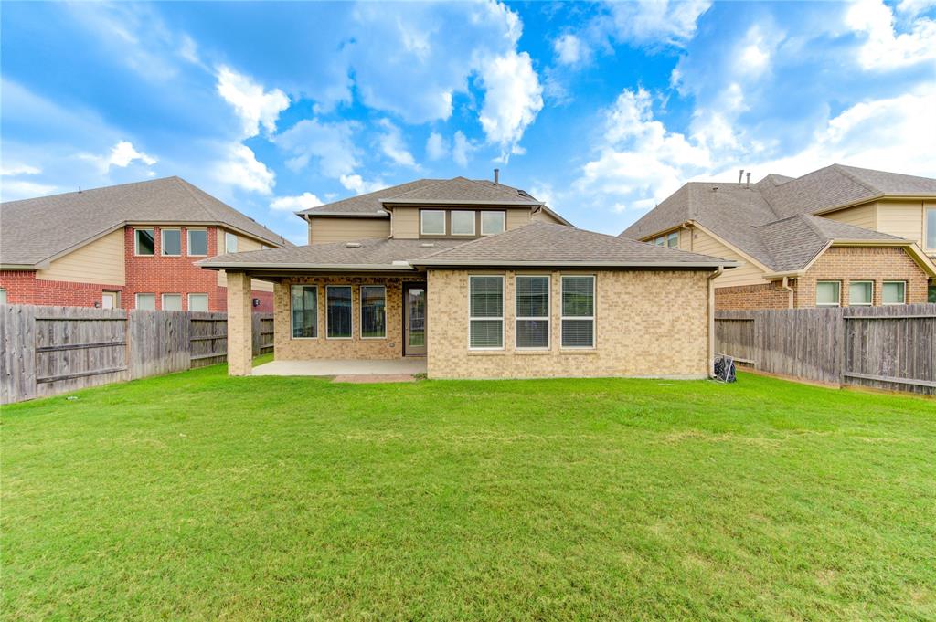 View of back of the house and covered patio.  Great view of all the windows.