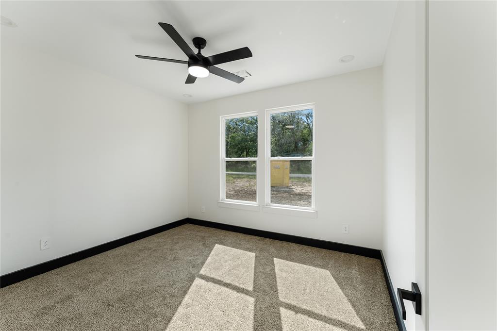 Great size windows to let in natural light, ceiling fan, carpet and black trim.