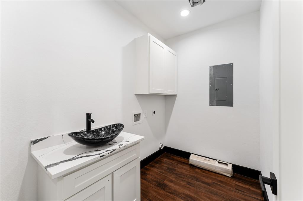 Laundry room is ready to go with extra cabinet storage and onsite sink.