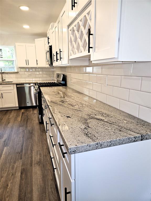 Granite countertops featuring subway tile on backsplash.