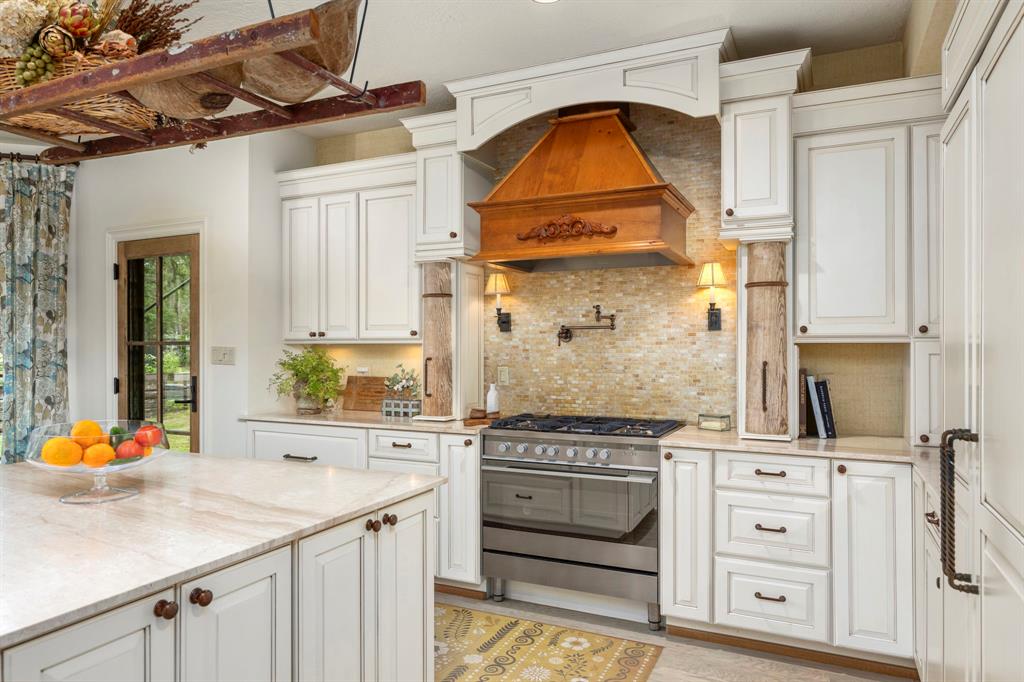 The fabulous Chef\'s kitchen offers a gas cooktop, honed marble countertops, copper farm sink, rich natural stone countertops, generous storage and plenty of serving space....and a bonus of amazing views!