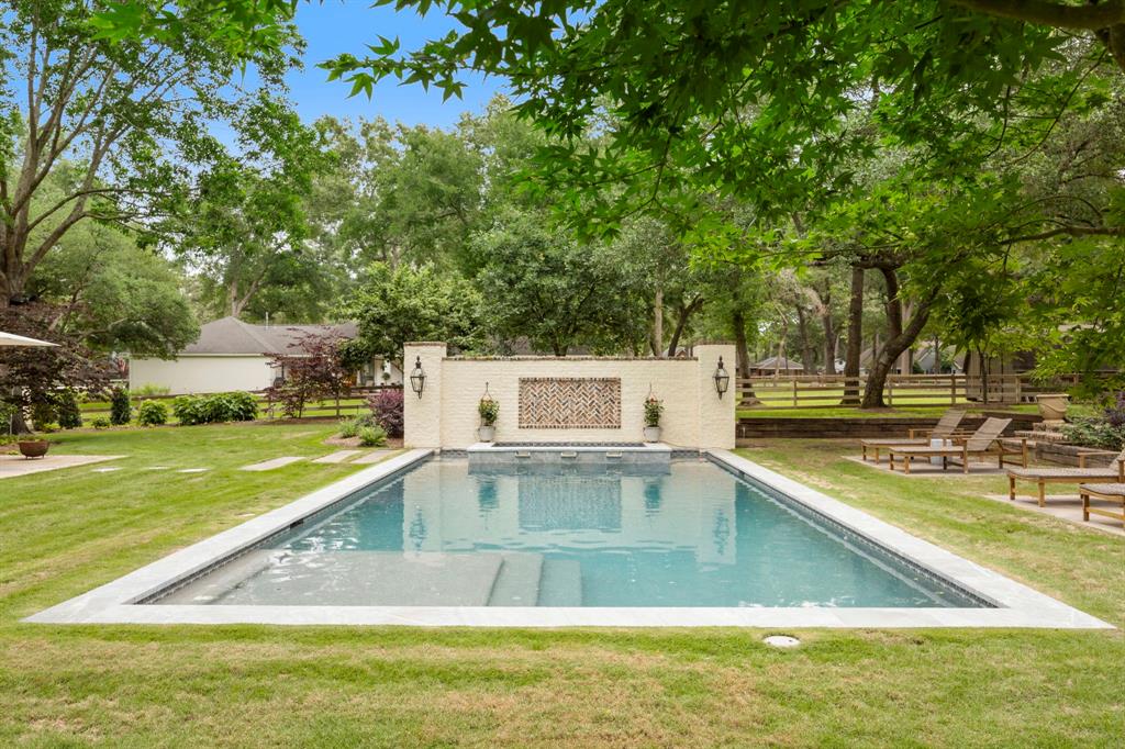 This recent pool includes an in-floor cleaning system, sand filter, heated and chilled water, spa and accented by neutral stone coping and natural grass. Generous lounge area on the right and seating for dining alfresco too.