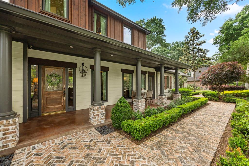 Welcome to the inviting front porch accentuated by the gorgeous reclaimed front door and manicured garden