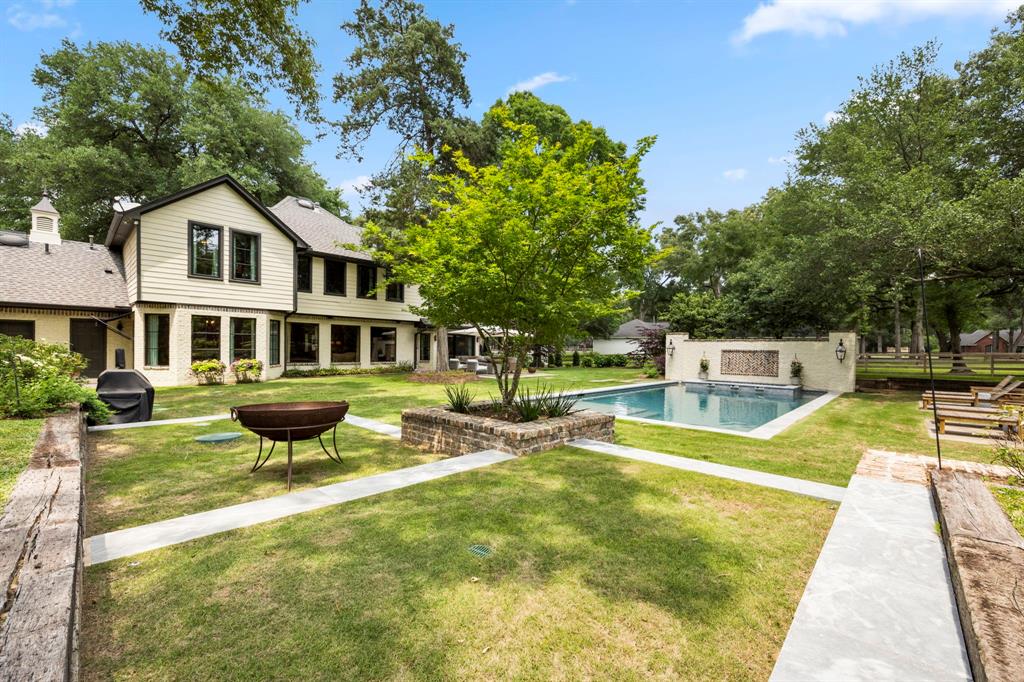 This sprawling living area offers views of this spa-like backyard retreat and green space; in addition to the outdoor living area nestled under the shade of the industrial grade umbrella.