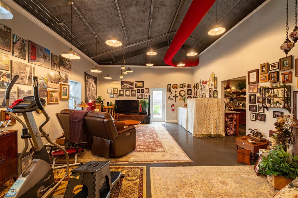 1610 N. Park St Living area with open ceiling. HVAC is a collapsable fabric duct with vent holes along the sides to push out the cooled air.