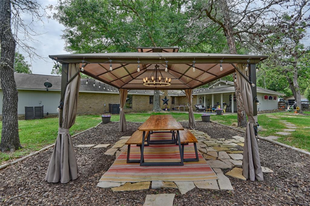 Outdoor dining at its finest! Paved area with pergola and adorable chandelier creates a great entertaining space!