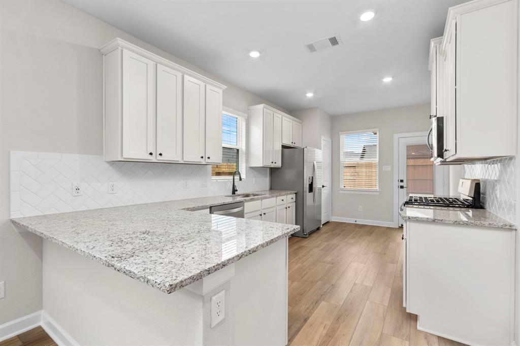 Featuring timeless white cabinets, stainless steel appliances, and granite countertops, the kitchen embodies classic design elements that never go out of style, ensuring enduring beauty and versatility for years to come.