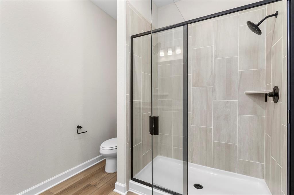 Welcome to the primary bathroom, featuring a stylish vanity with plenty of room for toiletries and a mirror that reflects natural light.