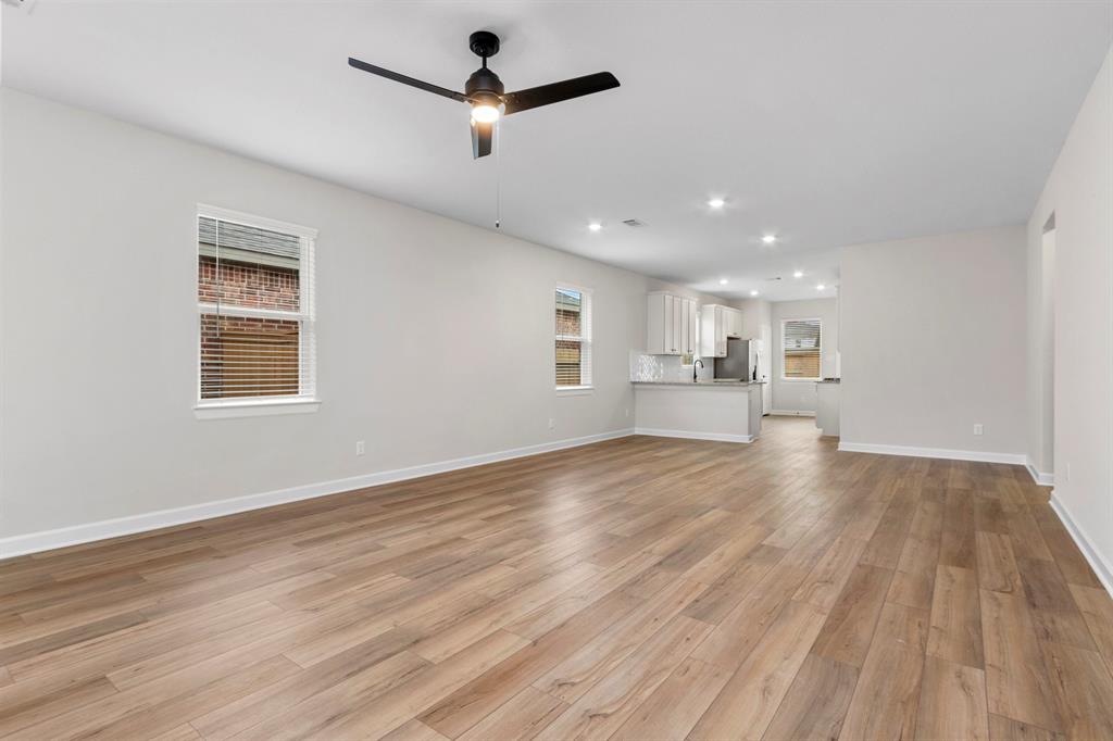 With its clean lines and minimalist aesthetic, the large kitchen exudes effortless chic, showcasing the crisp contrast between the white cabinets, sleek stainless steel appliances, and luxurious granite countertops for a sophisticated yet approachable look.