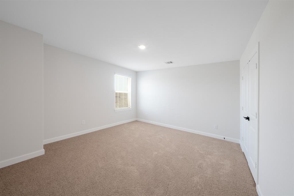 In the secondary bedroom, a large window infuses the space with brightness and warmth. With its cozy ambiance, this room is the perfect place to unwind after a long day.