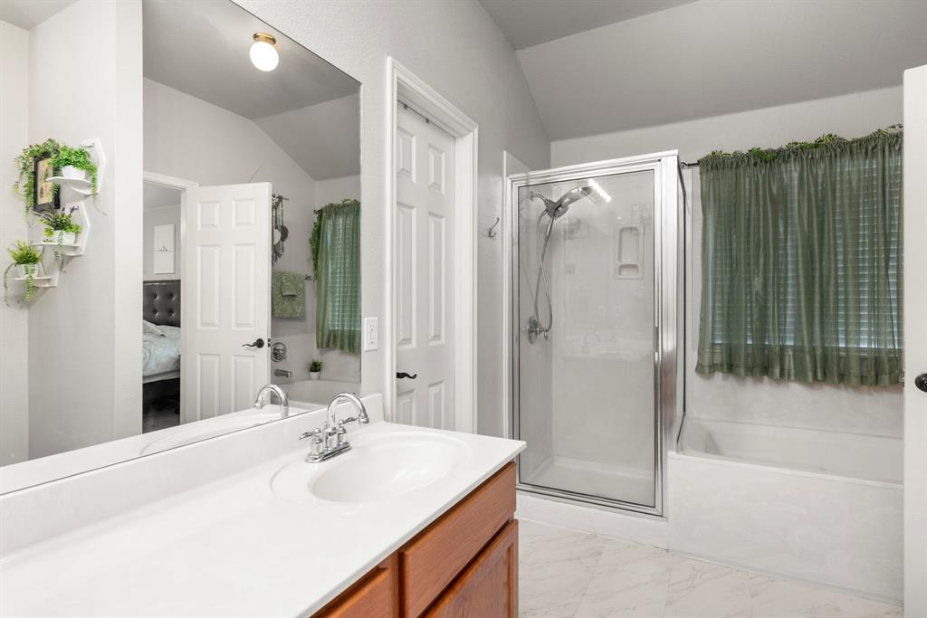 Double sinks and a separate shower and tub. The walk-in closet is just ahead.