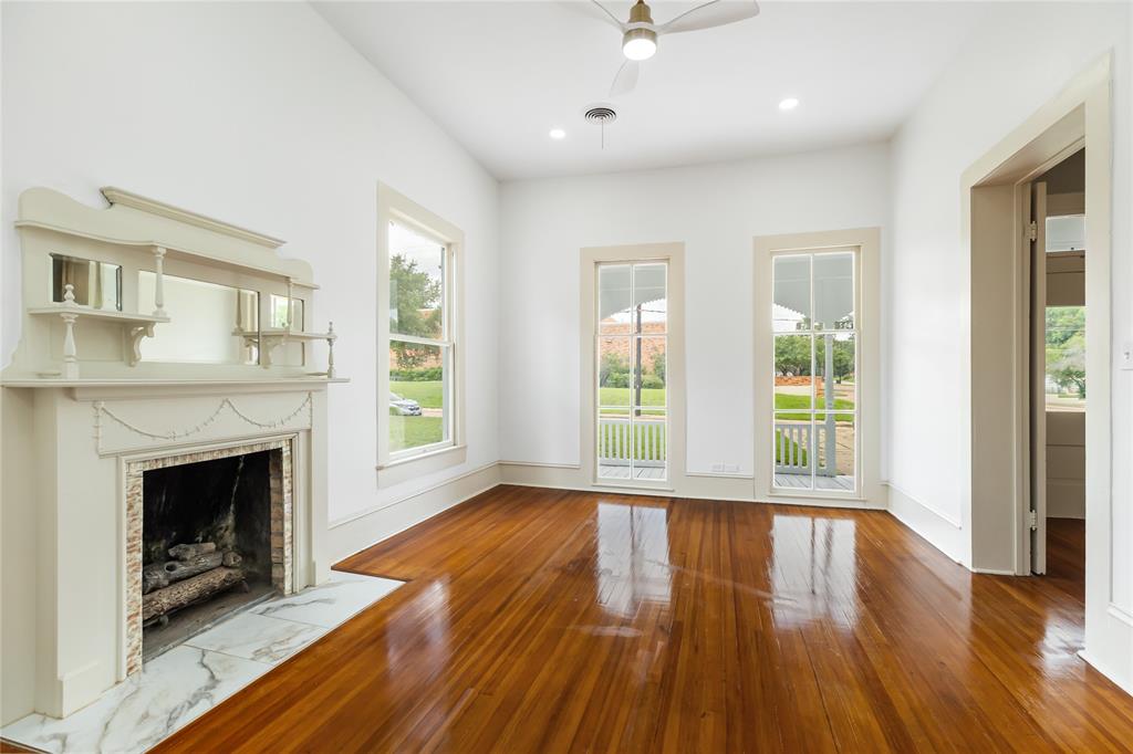 Front living area with wood burning fire place and refurbished wood flooring