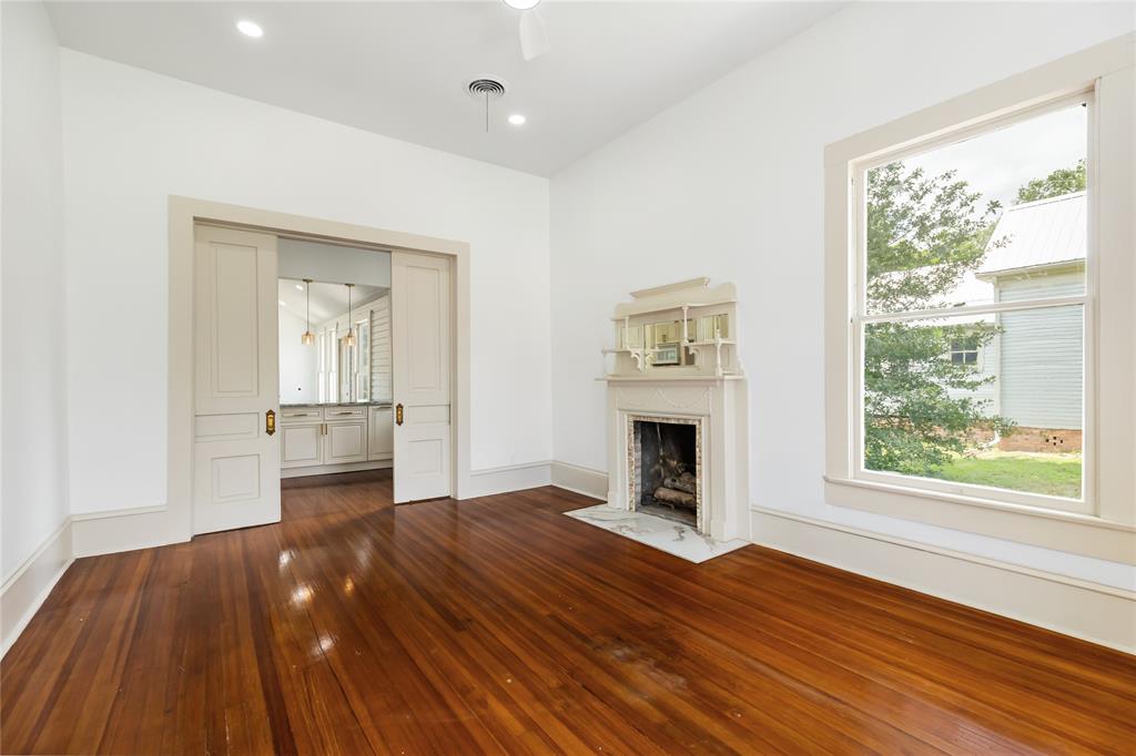 Front living area with wood burning fire place and refurbished wood flooring