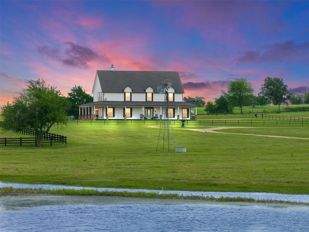 Situated in close proximity to Houston and ROUND TOP, this extraordinary New Ulm ranch offers many versatile opportunities. Sitting on 60+/- acres of rolling land is an impressive 2 story 4,308 sqft home showcasing rolling hills & captivating views. With 4 bdrms, 3 1/2 bathrooms, 2 living areas, office, & 2 bonus spaces on the upper level, this residence provides ample space for comfortable living. It also offers amenities such as a swimming pool, hot tub, and 4-car carport. The wrap-around porch provides a great setting to admire the +/-3-acre bass-stocked lake. This property offers 2 well designed horse facilities, an indoor horse walker, well-lit arena w/roping boxes, newly constructed workshop, party barn w/a 1 bdrm/1 bath apartment. The entire property is fenced & cross-fenced w/pipe/treated boards. Access to the ranch is granted thru 2 entrances, both equipped w automatic gates. Not into horses? Imagine what a stunning wedding venue, Airbnb, home or weekend retreat this could be.