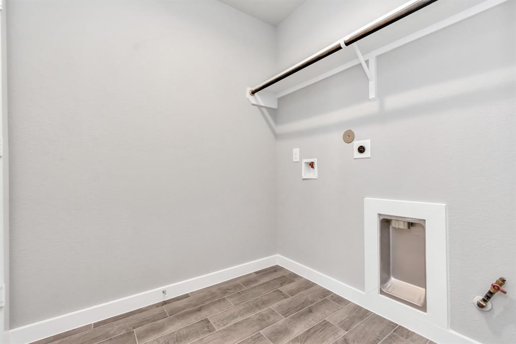 A perfect blend of functionality and comfort. Laundry room, thoughtfully equipped with shelving for effortless organization. Both gas and electric connections available. Sample photo of completed home with similar floor plan. As-built interior colors and selections may vary.