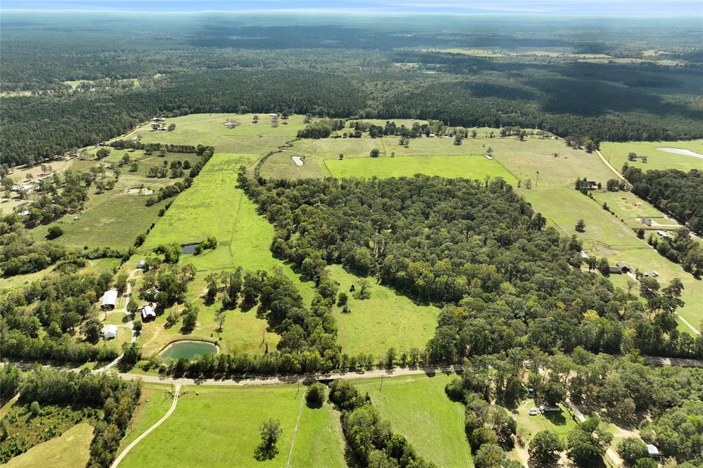 Discover the ultimate country lifestyle and endless possibilities on this stunning 90-acre homestead. The property is gated, fully fenced and cross-fenced, with two retention ponds, a scenic creek and spacious pastures. Approximately 40 acres is wooded and under brushed making it ideal for hunting, riding or nature watching. The charming primary farmhouse boasts rustic wood beam ceilings, durable vinyl plank flooring and an inviting open-concept living area with cozy fireplace. The primary suite is located on the first floor along with two guest bedrooms upstairs. The versatile office could easily serve as a 4th bedroom. The back porch with outdoor fireplace is the perfect spot to take in the view of the surrounding fields. The second home on the property with 3 beds & 2 baths is an ideal guest house, in-law suite or rental property for supplemental income. Additional outbuildings include a 40x100 barn, 36x60 barn with electric and a 30x40 shop with slab, full bathroom and electrical.