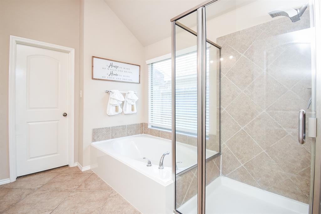 walk into relaxing master bathroom with tub and separate shower