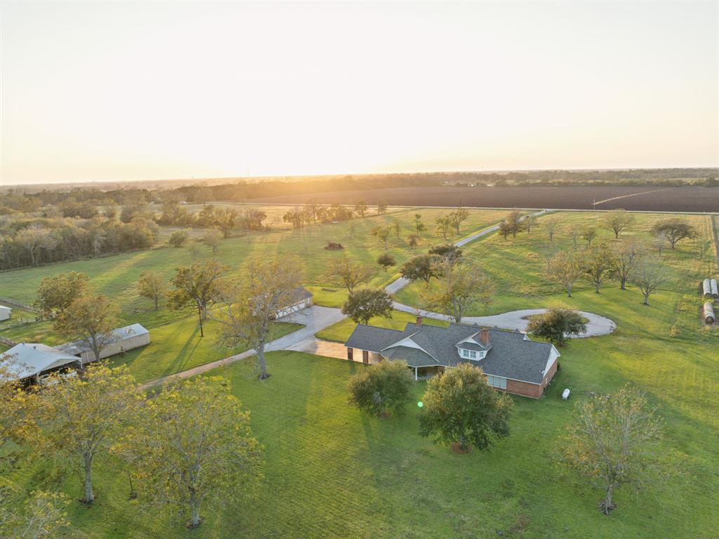 This 33-acre fully-fenced estate with a private driveway gate and distinguished circular drive leads to a 4,500 sq ft charming country residence. This expansive property also features a 5-bay workshop (one enclosed with A/C), attached 15'x15' storage room, covered work area. A 24'x24' barn connects to 24'x24' covered carport, alongside 20'x48' covered equipment storage and 4 horse stalls. Additional equestrian amenities include 5 paddocks, roping arena and pond. Elegantly updated home offers 4 bedrooms, spacious family room, formal dining, island kitchen, and two game/flex rooms. Large patio and 2-vehicle carport provide convenient parking and outdoor entertaining options. The home boasts rich engineered wood floors, 2 fireplaces, multiple built-ins, shutters, crown molding, security system with cameras, premium lighting, 3 geothermal AC/heating units, new roof, sprinkler system and more. Adjoining 30.5 acres is available for purchase, totaling 63.5 acres.