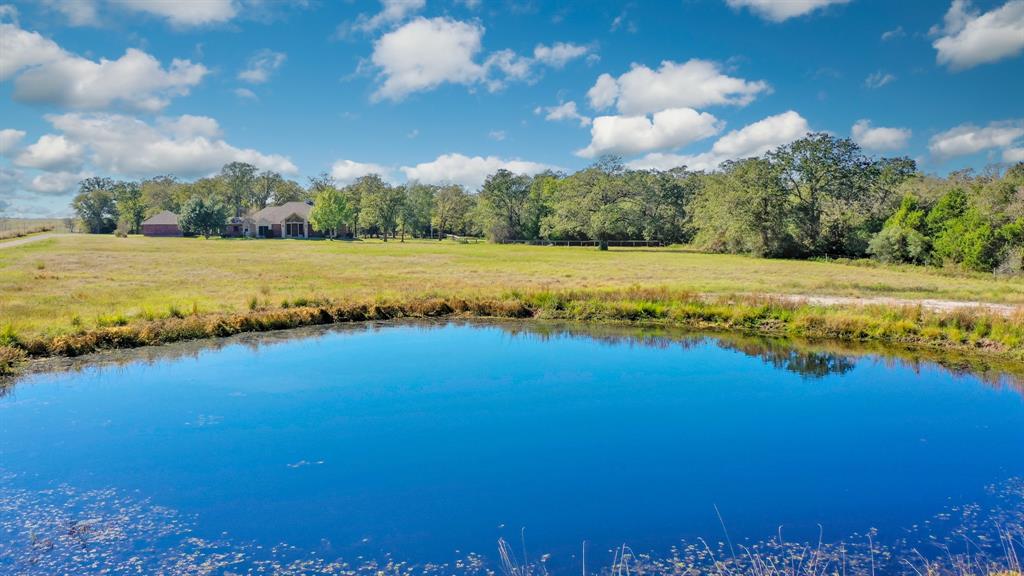 The Double J Ranch is an all-around property located in the heart of Texas, just outside the Madisonville, TX offering a quiet country setting.  Constructed in 2001, the 2776 SF home overlooks 29.00+/- Acres presenting a gentle rolling terrain, approximately 30% open and 70% wooded with a variety of native trees.  The 4-bedroom, 2.5 bath estate includes an open design, waterproof luxury vinyl plank flooring in the main area, a spacious living room with a vaulted ceiling, fireplace, a large dining area, walk-in pantry, kitchen island, large windows exposing fabulous views of the property, and a large covered back porch.  Outdoor amenities include a manicured garden area, and a fully functioning 1200 SF guest house with a 2-bedrooms and 1-full bath.  The ranch also has a 30'x40' barn with electricity and water in place, a pond, fence, and evidence of abundant wildlife.  This prime property is minutes from I-45 access and is centrally located between Houston, Dallas, BCS and Palestine.