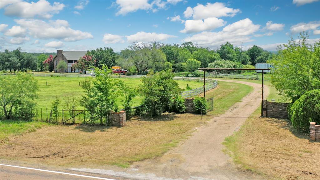 Discover the perfect blend of space, opportunity, and natural beauty with this expansive 56.69-acre property. Just 10 minutes from I-45, this picturesque ranch features a 4,512 sq. ft. home with 4 spacious bedrooms and 2.5 baths, offering ample room for family, guests, or a remodel to suit your vision. The home boasts impressive, vaulted ceilings with massive wood beams, creating a dramatic centerpiece with rustic charm. The land is a true gem for agricultural and recreational use. Ideal for cattle, the property is fully fenced and cross-fenced, equipped with a barn, runs with sheds, a large arena, and a serene pond, perfect for livestock or leisurely afternoons. If you’re seeking a working ranch, a private retreat, or the chance to create your dream estate, this property offers versatility and convenience. Don’t miss this exceptional opportunity—schedule your viewing today!