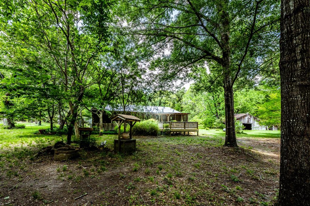 Great opportunity for quaint country living on 29.68 Acres in top rated Lovelady ISD! Peacefully secluded yet close to town, this property has a beautiful natural setting with a mix of pine timber and hardwoods.  The 3 bedroom, 2 bath home features authentic wood floors, open concept living with kitchen/dining combination, screened in front porch and a deck overlooking your private pond. Updates include central HVAC, upgraded pex plumbing and new gas range. Additional buildings include older barn, detached garage and a separate bungalow with water & electricity. Lovelady is located between Crockett and Trinity, approximately 14 miles from each. Come check out this getaway!