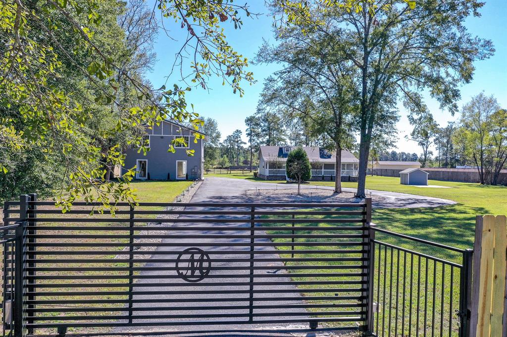 3 acre property close to Conroe and The Woodlands. An iron gate and fence greet you at the street. A 3 bedroom 2 full bath home with a 48'X10' covered front porch. A brand new roof was put on the main house 2 months ago. The interior was updated over the last couple of years with new cabinets, counter tops, appliances, and strip vinyl flooring, and lighting. Both bathrooms have been updated, the main bathroom was reconfigured to include a large walk in closet.  The 23'x10' back deck is a nice place to spend the evenings.  After viewing the main house take a look at the 40'X30' tall ceiling garage with 2 -  12' wide x 8'6" tall garage doors where all kinds of stuff can be stored.  Above the garage is a full 3 bedroom 1400 sq ft apartment with 1 bathroom, kitchen and breakfast, family room and balcony sun porch.  The stairs to the apartment has a chair lift as well.  An air conditioned insulated 24'x20' shed with loft and a 10x20' shed are on the property as well as a pond and stable.