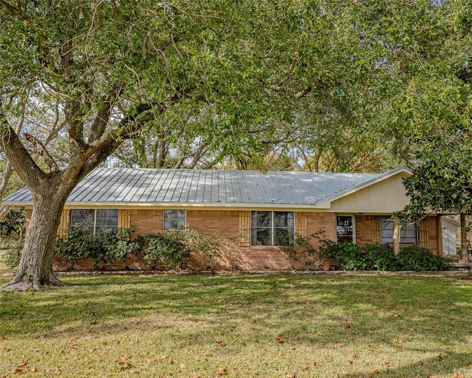 This ranch-style home is set on 6.4 acres outside the city limits, yet just minutes from town. The brick exterior, durable metal roof, & inviting front porch exudes curb appeal. Inside you will find a spacious living room and kitchen open to the dining room, which features a wall of elegant built cabinets. The stylish kitchen has granite countertops, stone backsplash, & white appliances. The primary bedroom includes a walk-in closet and an en-suite bathroom with a shower. Two well-sized guest bedrooms share access to the hallway bathroom which has a walk-in shower. 2 car detached garage. The backyard provides ample space for things like raising animals and gardening. A horse barn is located at the rear of the property and includes three stalls, a tack room, and a storage room. To the left of the house there's approx. 4 acres that are currently used as pasture, with a drainage district easement of approximately 40'. Additionally, there is a 50-amp hook-up for an RV.