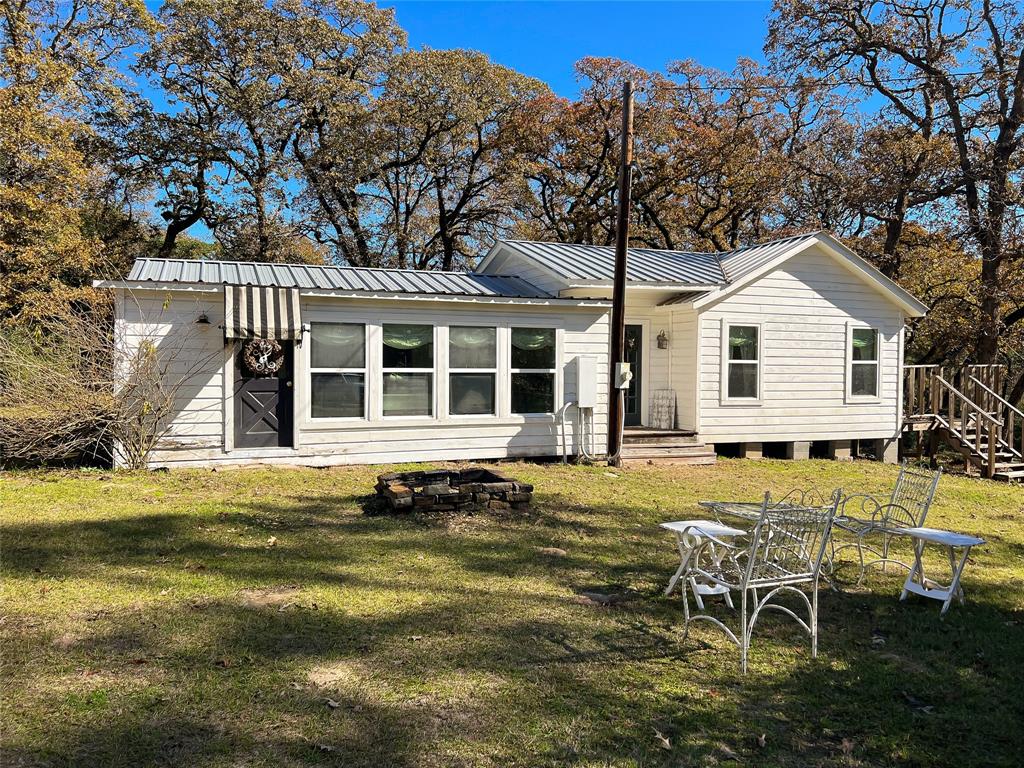 The cottage of your DREAMS! This new listing is a quaint home on 5.33 acres located on County Road 3142 between Buffalo and Centerville. Enjoy the stunning primary bedroom with double French doors leading to an attached deck where you can sip coffee and watch deer graze. Or cuddle up in the family room off the eat-in kitchen. Or maybe the sunroom is more your style! This one is being sold furnished and is in a premium location between Dallas and Houston for a weekend recreational property! Everything is ready to go and each room is better than the last! The property itself is gated and cleared beneath towering mature trees. Serene doesn't even begin to cover it. In addition to the 2 bedroom 2 bath cottage, there is the sweetest bunkhouse ready to be finished out, a small tool shed, a detached garage with one roll up door, and a full RV hookup. Oh and a chicken coop! Call us today!