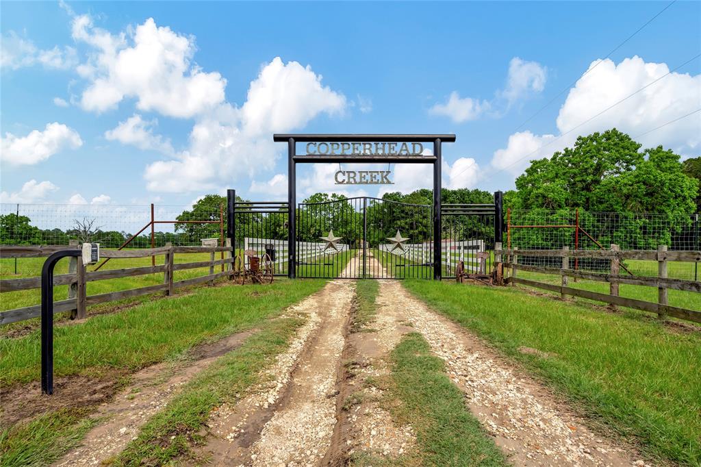 Experience the best of country living, a unique 69-acre property with an AG exemption for timber and game. The 139-year-old house showcases historic elegance with a stone fireplace, antique stained glass, and original hardwood floors. The fully remodeled master bathroom adds modern luxury. This estate features a guest house, 4 fenced pastures for horses or cows, a pool, 2 ponds, a large shop, chicken coop, and several barns, offering both sophistication and functionality. 40 acres of timber are fully enclosed with a high game fence, perfect for hunting White-Tail, Antelope, Red Deer, and Axis. It also includes a 2-car garage, covered carport, and fully fenced surroundings for security and privacy. The guest house features 1 bedroom, 1 bathroom, a living room, and a kitchen. Located just 7 minutes from Trinity and 25 minutes from Huntsville, this secluded oasis offers the tranquility of nature. Explore this exceptional property in person to fully appreciate its beauty and potential.