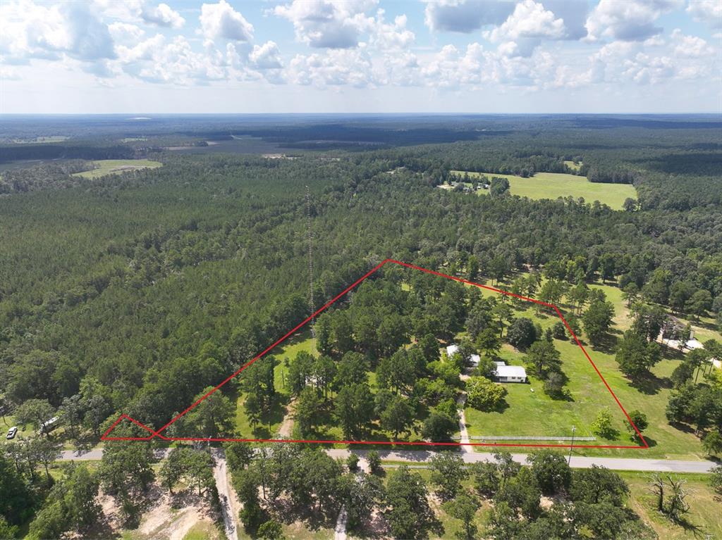 Just North of Livingston, TX, this property offers a 2 Bed/2 Bath home, 2-car garage, 1 Bed/1 bath garage apartment, and a shop all on 7.679 Acres! The home has vinyl plank flooring, central AC and heat, and a gas stove. The kitchen offers a ton of storage, wine cooler, and a large farmhouse sink. The primary bath has double sinks, a separate shower, and a walk-in bathtub. Covered front and back porches. The garage apartment includes a full bathroom and bedroom with plenty of open space for a workout room, guest house, or personal office. Along the back of the apartment, you will find another 1 car garage/shop to utilize for storage. 
Fully fenced in front and backyard. Sitting on a beautiful lot with scattered trees providing both privacy and shade during the warmer months, this private oasis is equipped with everything that you need.
*There is a Right of First Refusal on the leased cell tower portion of the property.