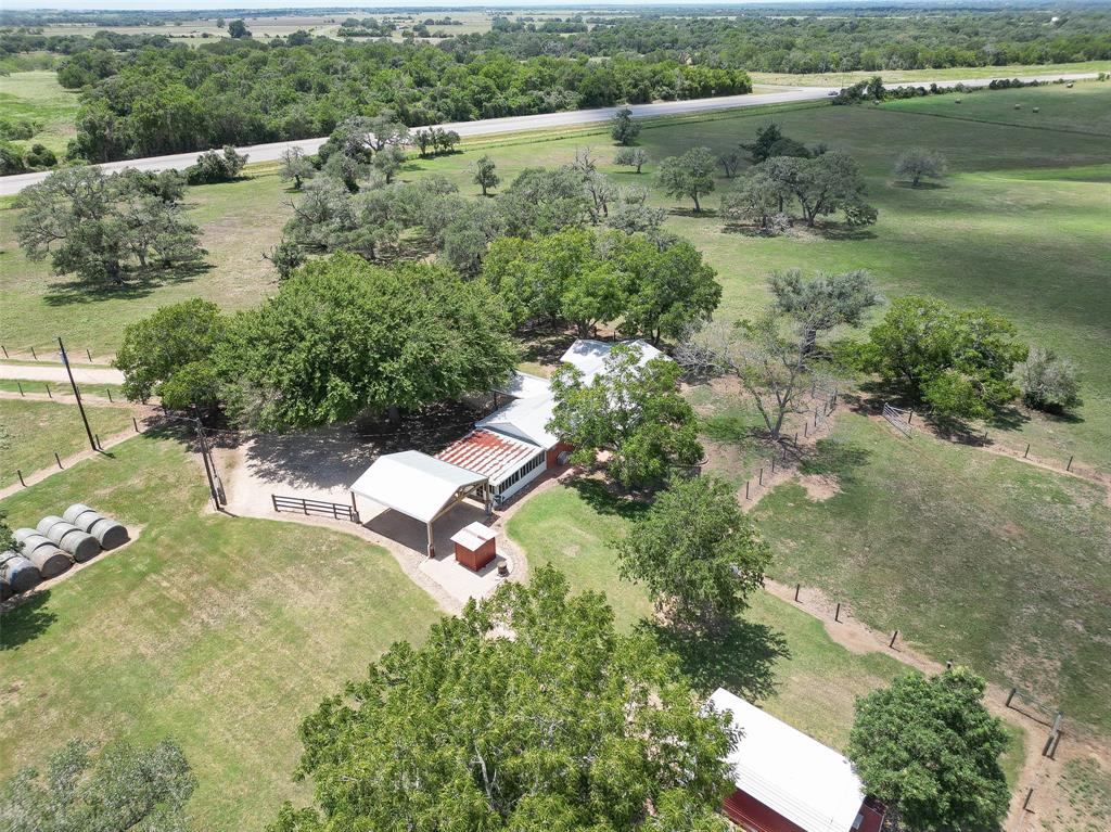 Stunning 31+ Acre Hilltop Property with Renovated Brick Home and Guesthouse. Nestled atop a picturesque hill, this property offers breathtaking views of scattered trees and lush hay meadows. With extensive frontage on Highway 77, this ranch is perfectly suited for cattle operations. Sturdy fencing, cross fencing, gates, and cattle pens. The brick home is set back from the highway, ensuring privacy and tranquility.  Main House has spacious family room and is connected to the kitchen. There is a sunroom with weathered barn doors. Tile floors are found throughout the home.  The Primary bedroom is a generously sized retreat.  The second bedroom is conveniently located across from the main bath. A large kitchen has room for dining within. Oversized screened patio. Large Carport/Pavilion.  The guesthouse has sleeping quarters, complete with a full bath and shower.  The grounds are well maintained.  A large wooden vintage barn has a smoke room for smoking sausage and other meats.