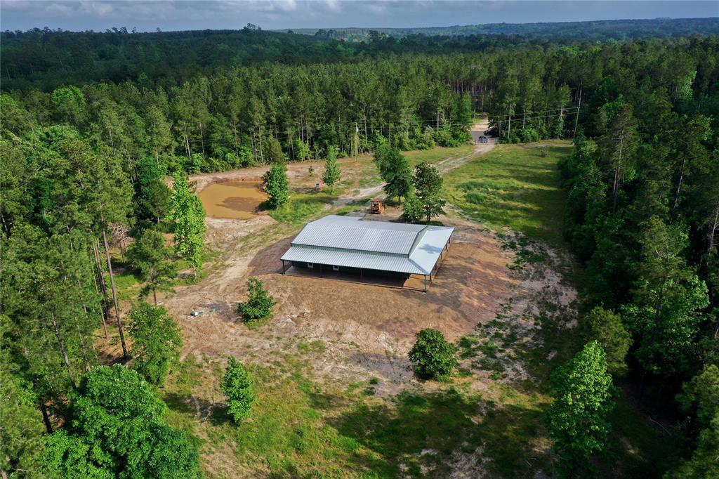 BRAND NEW CONSTRUCTION! Presenting a stunning 24.2-acre property with easy access to Highway 59 & Lake Livingston! Experience country living at it's finest in this picturesque location, near amenities, schools, and medical facilities. The property boasts two manmade ponds & a mix of timber and pastureland suitable for various uses. Ideal for cattle or equestrian activities, it also offers excellent hunting opportunities with abundant wildlife. This beautiful property features a newly built 1,927 SF country-style home with high-end finishes, premium wood-tile floors, Quartz countertops, soft close hinges & drawer slides, stainless steel appliances, ceiling fans, 8 1/2 inch doors, 3 1/2 inch door & window casings, stained wood doors, vaulted wood plank ceilings, new treatment septic system, and more! Functional, spacious floor plan with open Kitchen/Dining/Living area, 3 bedrooms, 2 bathrooms, and a wrap-around porch showcasing endless views. Don't miss out on this unique opportunity!