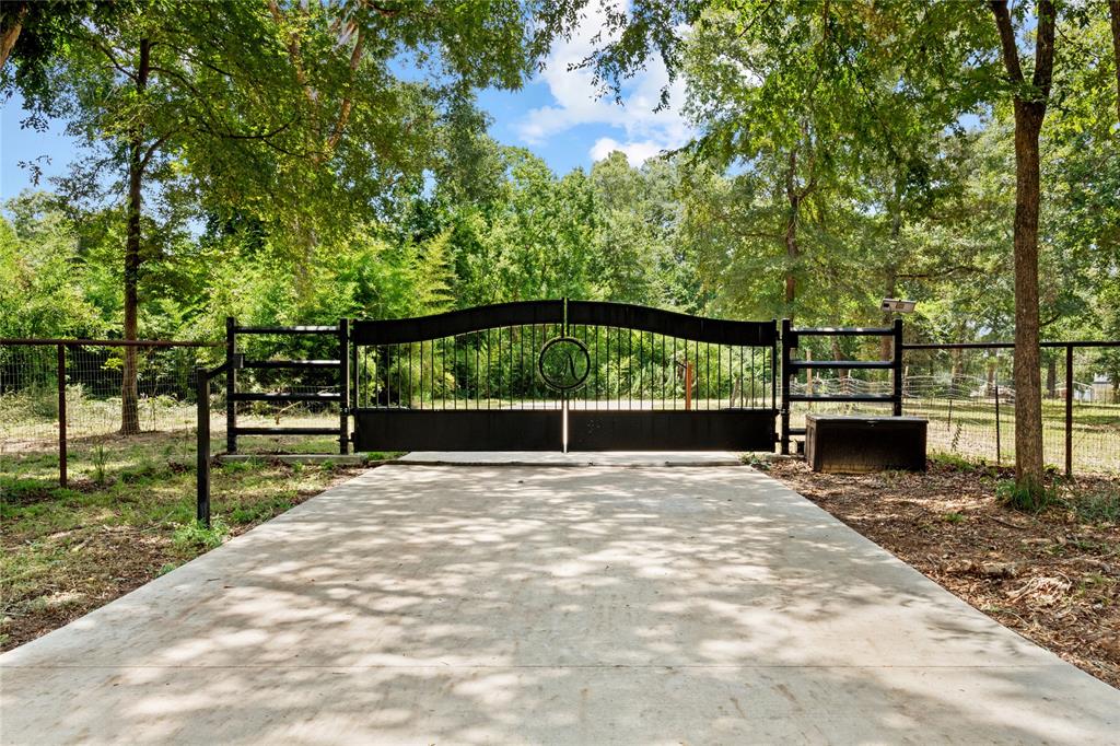 Just 45 minutes North of Downtown Houston, nestled on a prestigious country road surrounded by nature, this property boasts 8 horse stalls with feed room, heater installed inside the barn, a full rodeo arena with LED lighting, and a stocked pond. The ranch house is set back from the main road for peace and quiet, this home can be removed for more pasture appearance. This property offers large oak trees providing shade. The concrete driveway leads to a double gate iron entrance, creating a grand entrance. Livestock animal set up, horse cutting pen, and cross fencing are just a few of the features that make this property perfect for animal lovers. Enjoy the sightings of many different kinds of wildlife. Excellent schools in this charming small-town setting. Just minutes away from Sam Houston National Forest which offers hunting, fishing, hiking and bike trails to embrace the beauty of nature. Build your forever home in seclusion surrounded by a beautiful view!