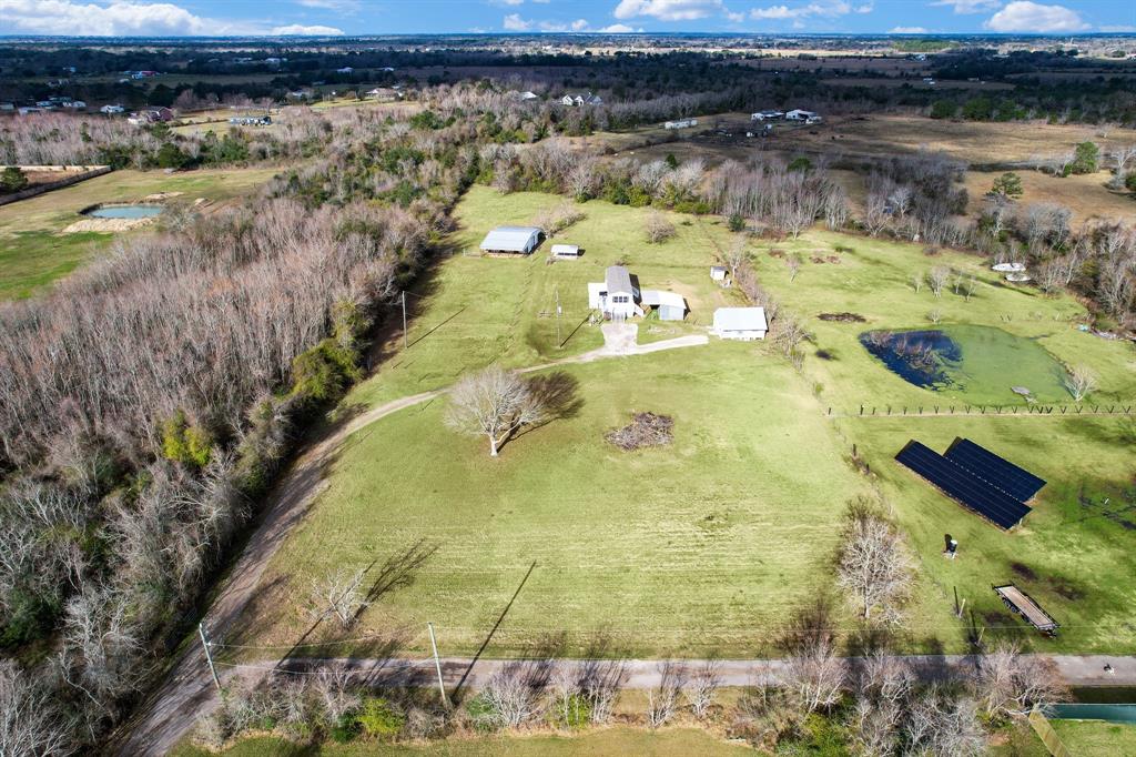 Enjoy 5 acres and the seclusion of a quiet country setting! Your own paradise awaits with a mobile home, tiny home, barn, shed, & carport! Mobile home is 868 sq ft & tiny home is 436 sq ft, not including porch area. Great income-producing properties, a great investment! Live in one home & rent the other (both homes are on separate meters), or use as a mother-in-law's quarters, so many options! Upgrades include granite countertops, new flooring, new roofs, new water heaters in 2022! The fridges, washers & dryers can be negotiated! Huge metal barn with 6 stalls (1296 sq ft) has a concrete slab-use it as a workshop, for your livestock, for your business or for storage. The large shed (336 sq ft) is on concrete too and the carport is 360 sq ft. This is a multi-use property, contact zoning about adding another unit-generate more income! Part of the property extends beyond the current fencing into the wooded area. Close to ACC & shopping!