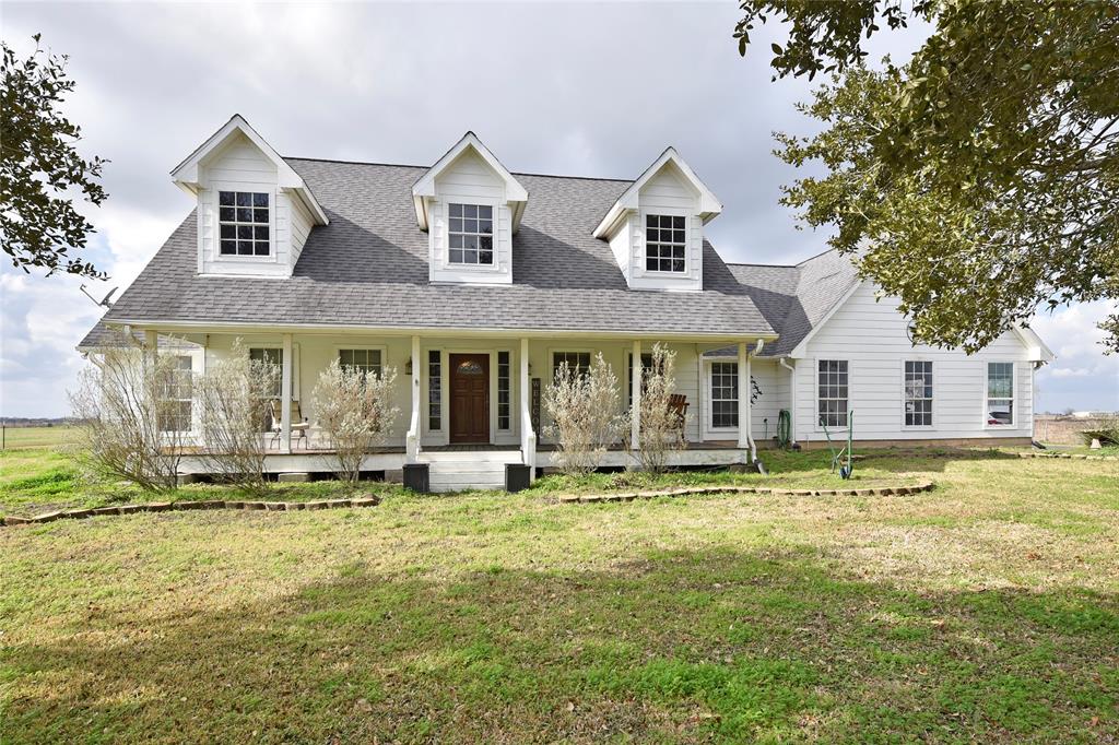 Follow the private road of this 17.8 acre tract lined with majestic live oaks to your 4/ 2 1/2 /2 farmhouse-style retreat in the country. This property boasts a stocked pond, large covered front porch, split design with spacious primary bedroom and bath, craft room, mudroom, and utility room. The kitchen features stainless appliances, gas range, and custom ash cabinets. Hardwood floors in the entry, family room, and dining areas, with tile flooring in bedrooms and baths. An unfinished second floor offers potential for expansion. Outside, a 40x60 metal barn with full bath, 40x50 metal farm shed, and early 1900's 1/1 house are included. 15-acre in ag exemption.