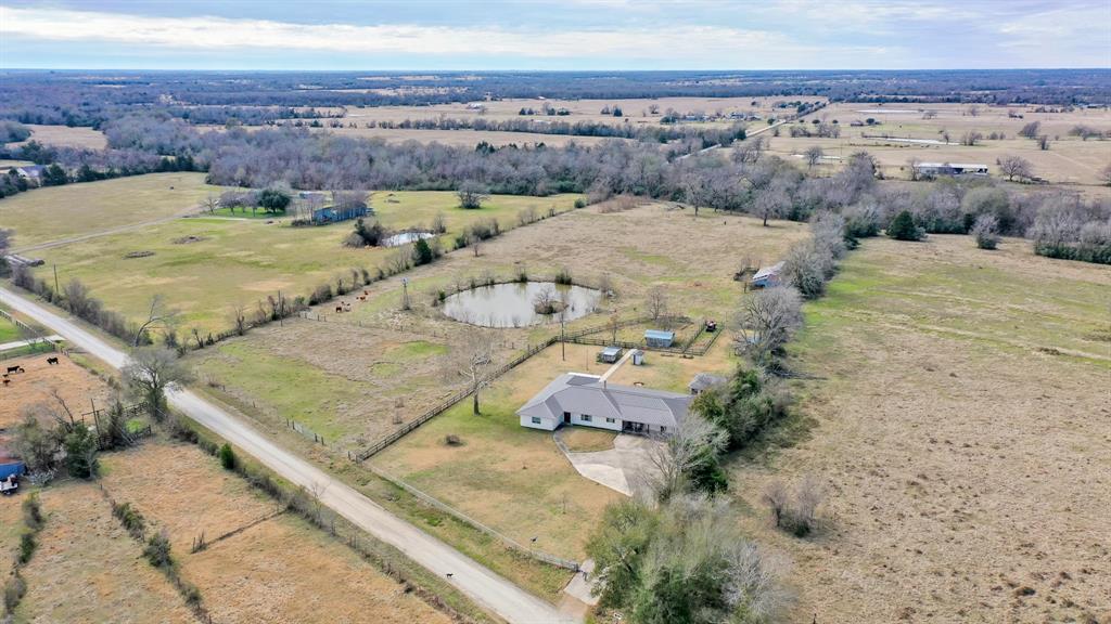 Discover the Black Sheep Ranch that offers a unique opportunity to own a piece of Texas history with this nearly 10 Acre ranchette. Nestled in a picturesque setting, this property provides a tranquil escape while being located near local amenities.  The sprawling home features 3 spacious bedrooms, 2 large full bathrooms, 2 living areas, a wood burning stove, an oversized bonus room, an office, and a detached garage.  Its versatile layout and picturesque surroundings create a captivating setting for daily living and entertaining.  Currently under an Agriculture Exemption for cattle, this tract is cleared with a few scattered trees, has a pond, fence and cross fence, an old barn, chicken coop, craft shed, and run in shed.  Beyond its role as a primary residence, this exceptional property provides endless possibilities as an investment as a short-term rental, event venue or as a personal retreat to escape the business of city life.