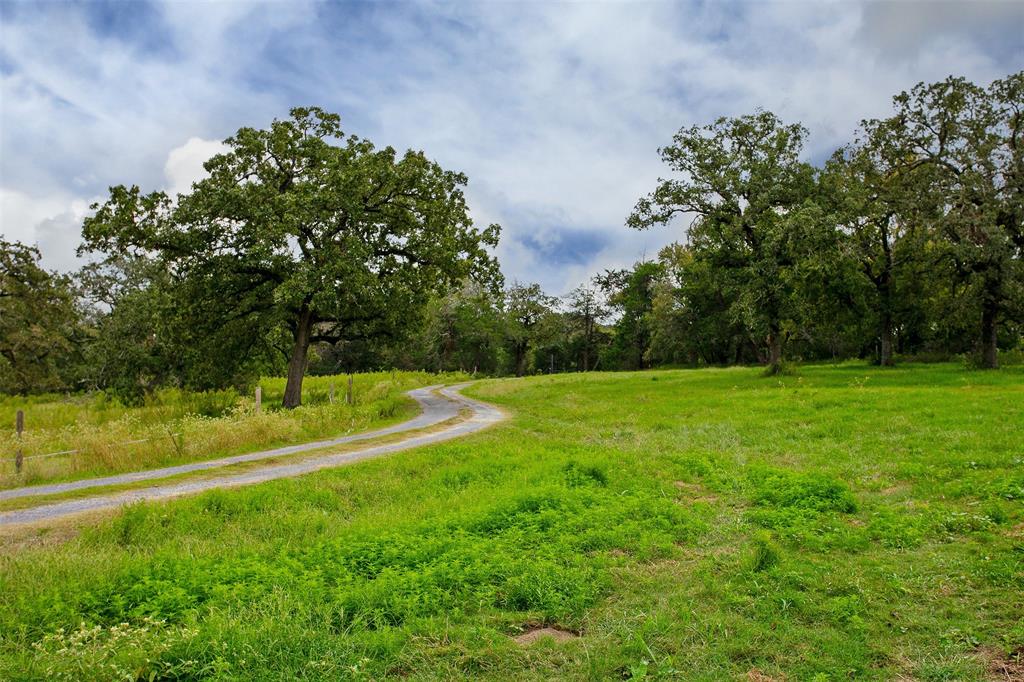 Welcome to this hidden treasure that offers the best of both worlds such as easy accessibility/location and seclusion with an absolutely stunning landscape. Upon entering the entrance from the black topped FM 39, you are greeted with a subtle winding driveway through the tranquil property up to the home, large mature trees throughout, long distance views of the property's rolling terrain, wildlife & the attractive 2 story home! The first level of the home offers an adorable farm house kitchen, walk in pantry, dining, primary bedroom with an en-suite bathroom, walk in closet with attached washer and dryer; the living area is open to the 2nd level with exposed wooden trusses & receives a lot of natural light from all of the windows & glass doors, renovated half bath is off of the living area. The long balcony on the 2nd level offers incredible views of the property, awesome place to see wildlife & relax! New aerobic septic in late fall 2021. Motivated seller, call today to come see it!