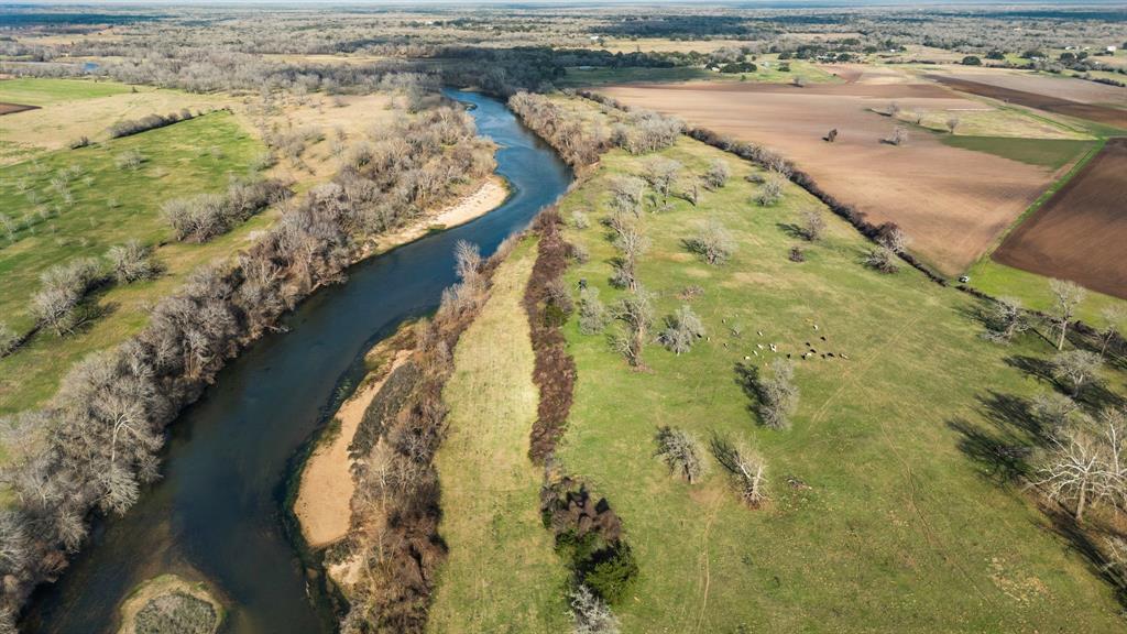 Discover an exceptional opportunity to own 63+/- acres of breathtaking land featuring approximately 1,200 feet of river frontage along the Colorado River. This rare river frontage property boasts a beautiful sand bar with picturesque views, offering the perfect spot for fishing, swimming, & relaxing by the water.

The landscape is adorned with towering mature trees, providing natural beauty and throughout the river bottom. With some fencing & cross-fencing in place, this land is well-suited for agricultural, recreational, or residential use. Additionally, electricity access is available, making development more convenient.

Located just a short drive from Columbus, this property offers easy access to major cities: only 1 hour from Houston, 1 hour from Austin, & just 2 hours from San Antonio. Whether you’re looking for a private retreat, a future homesite, or an investment opportunity, this stunning piece of riverfront land is a must-see!